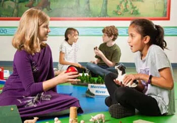 Children playing and talking with toys in an educational setting.