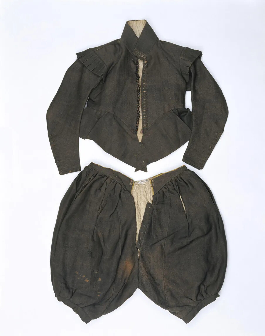 A pair of knee-length pants and a long-sleeved jacket in faded black cloth.
