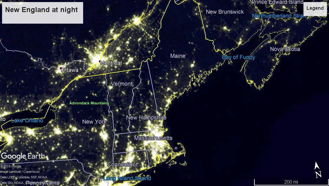 A colored screenshot of the New England states and New York, as well as parts of lower Canada, as represented at night from Google Earth. The states are outlined in white and have their names written inside each state. Different areas of the map show groups of yellow lights, while the rest of the map is black and gray.