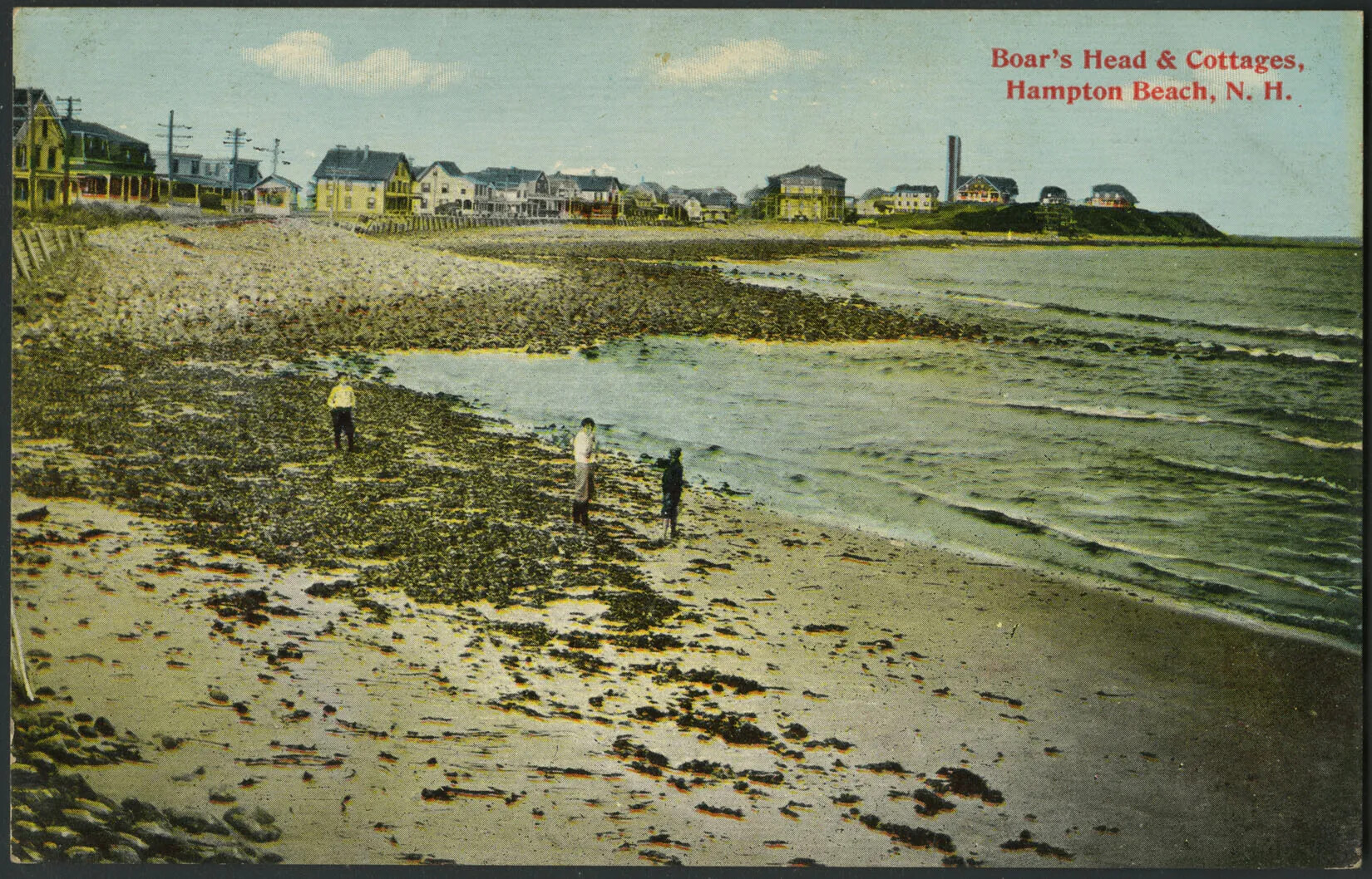 A colored postcard of three people standing on a rocky beach. There are several houses of different colors lining the back edge of the postcard. The words "Boar's Head & Cottages, Hampton Beach, N. H." are written in red text in the upper right hand corner. 