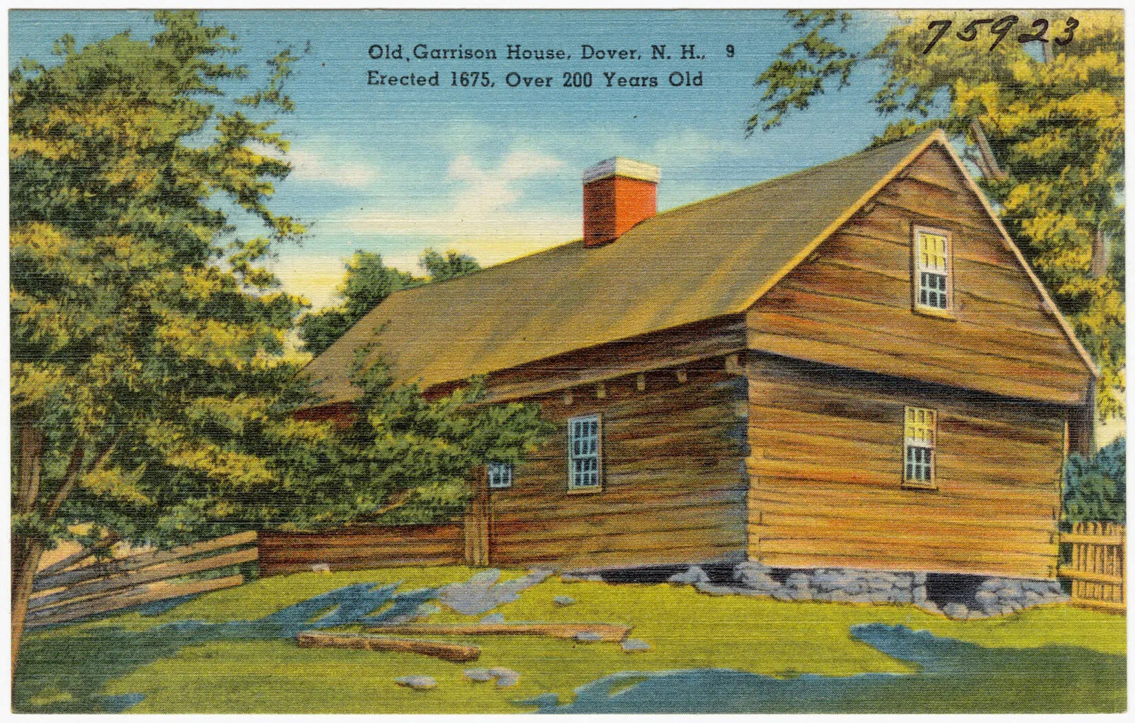 A colored postcard of a singled-storied log cabin with a stone foundation. A window to the cabin's attic is seen on the cabin's right side wall. The land on which the cabin sits is covered in green grass and trees. The property is bordered with fences made from horizontal wooden posts. The title of the postcard, located centered along the upper border, reads "Old, Garrison House, Dover, N.H., 9/Erected 1675, Over 200 Years Old."