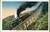 A color postcard of a train with one passenger car has a caption reading "Jacob's Ladder, Mount Washingon Railway, White Mountains, N.H." The train is descending from a very steep part of the tracks on the side of a mountain, which is covered with scrub and rocks. The part of the track the train is on is built up on a small bridge made of timber to keep the track as consistent as possible. 