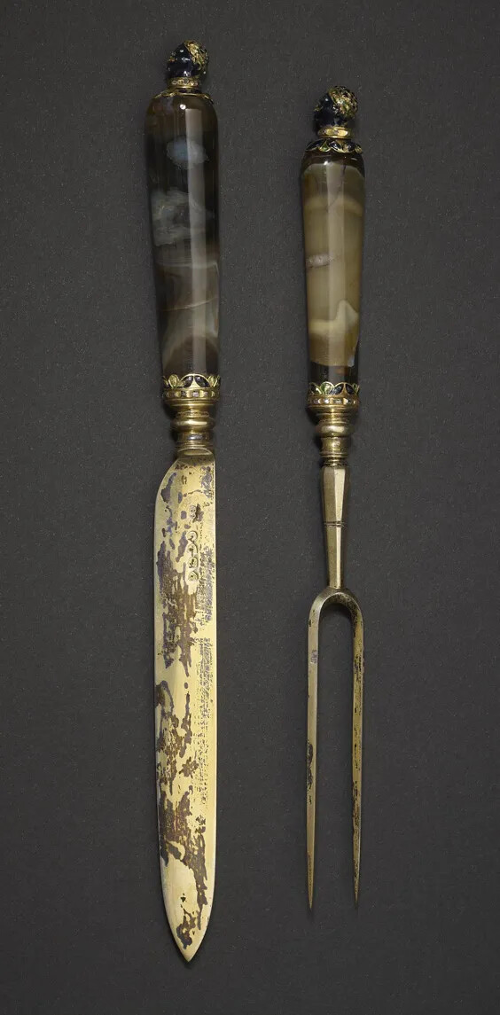A knife and two-pronged fork, with decorated handles.