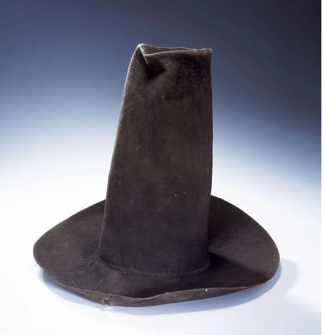 A tall cloth hat, made from black fabric.