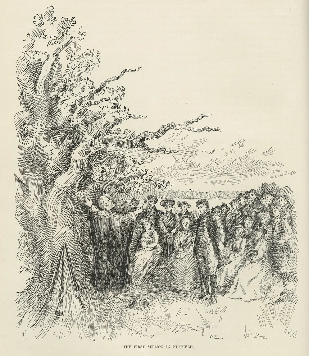 A black and white drawing of a large group of men and women standing and sitting to the right of a large tree. In front of the tree is a man facing the crowd, with his arms raised up in front of him. The title of the drawing, located along the bottom border, reads "THE FIRST SERMON IN NUTFIELD."
