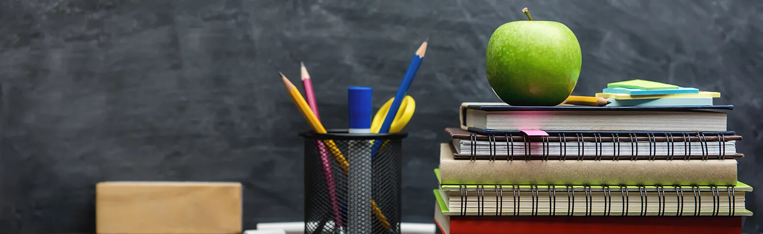 Teachers desk with school books and other school items