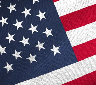 Zoomed in-on image of the American flag, showing portions of the starts and stripes at an angle.