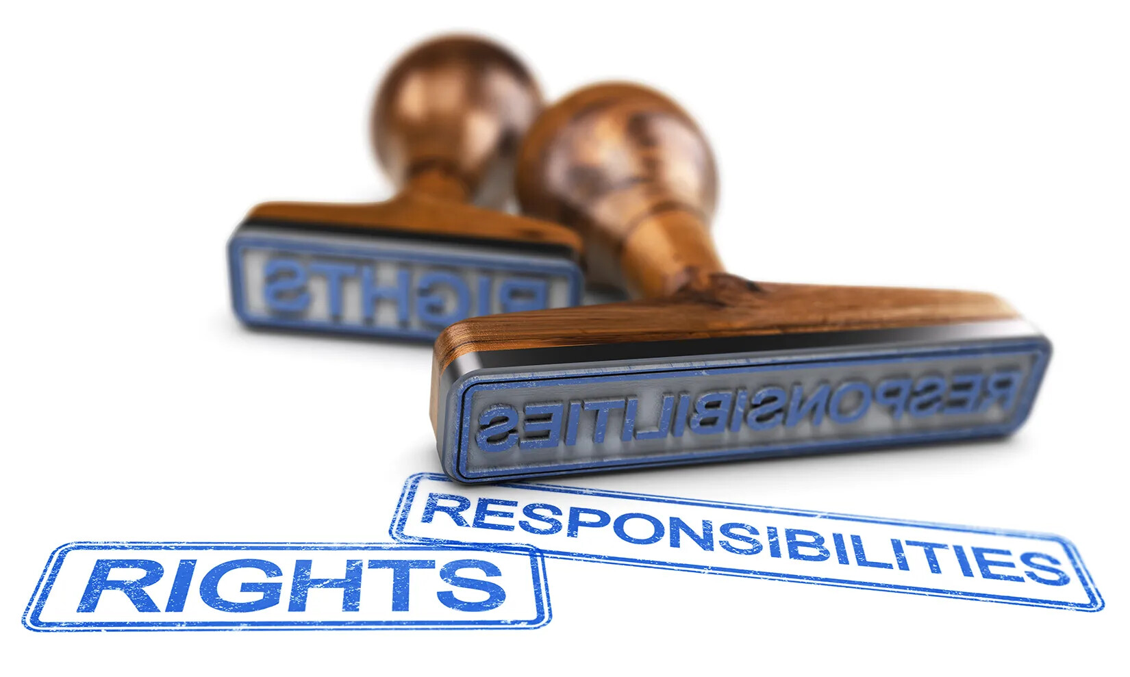 A colored photograph of two stamp presses with rounded wooden handles lying flat on a white surface. The words "RIGHTS" and "RESPONSIBILITIES" are stamped in blue ink directly in front of the stamp presses.